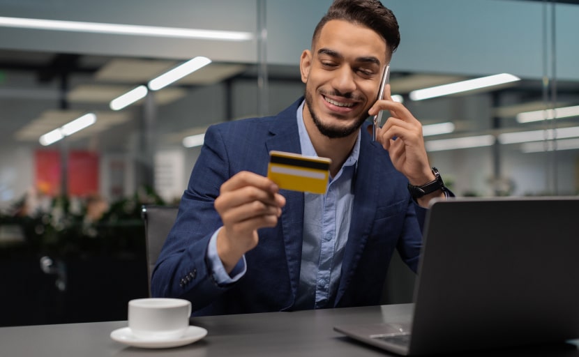 Ein Mann telefoniert und verwendet eine Firmenkreditkarte für Mitarbeiter.