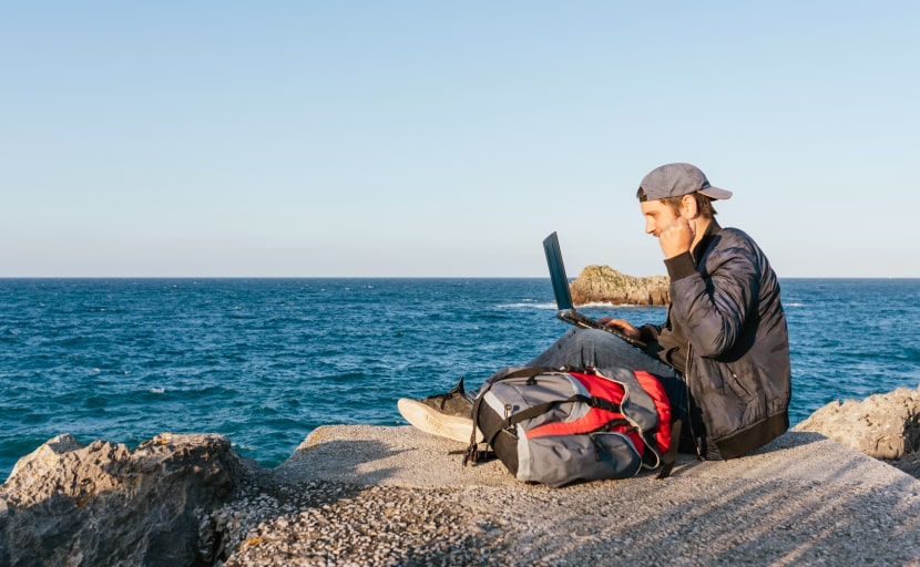 Ein Mitarbeiter arbeitet als Digital Nomad am Meer.