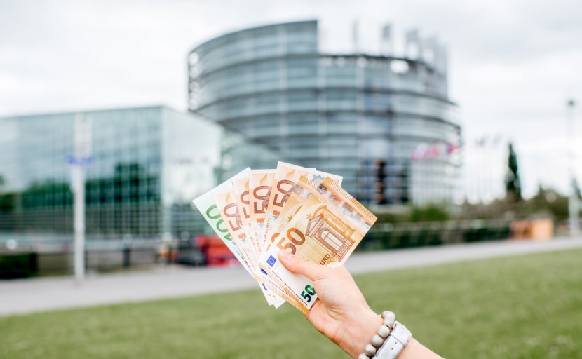 Eine Frau hält ihre Inflationsausgleichsprämie in Euro in der Hand.