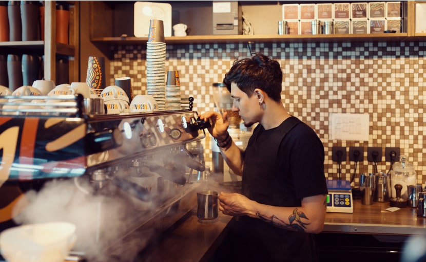 Ein Mitarbeiter arbeitet als Minijob in einem Coffeeshop.